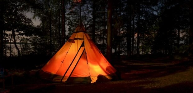 Camping gift ideas – lit tent in the forest at night