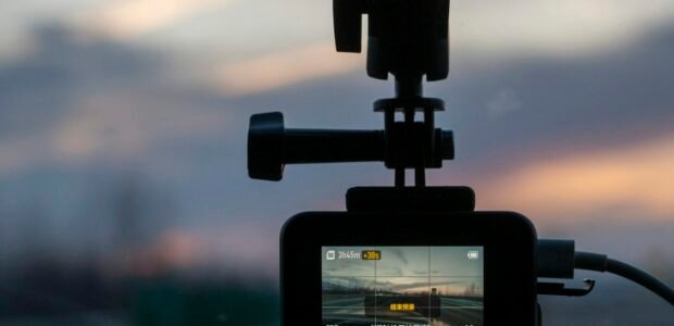 Dash cam mounted on a car windshield at sunset