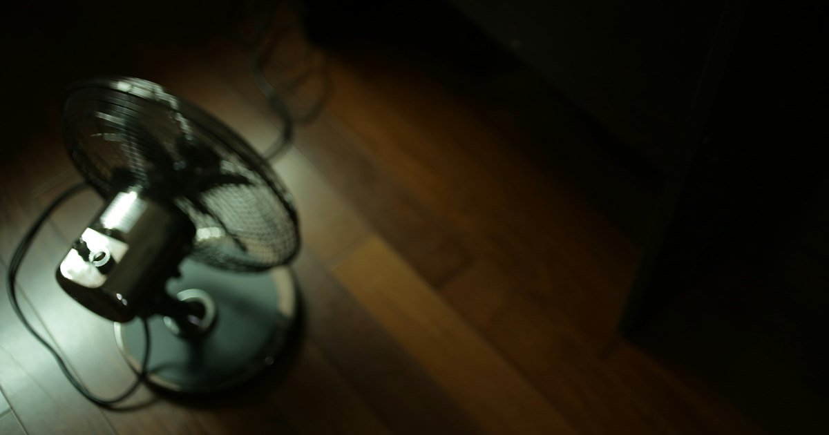 A desk fan next to a neck air conditioner as a cooling alternative
