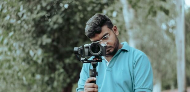 Person holding a camera mounted on a smartphone gimbal stabilizer, from our smartphone gimbal buying guide