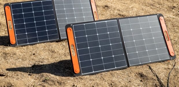 Portable solar panel set up beside a power station outdoors