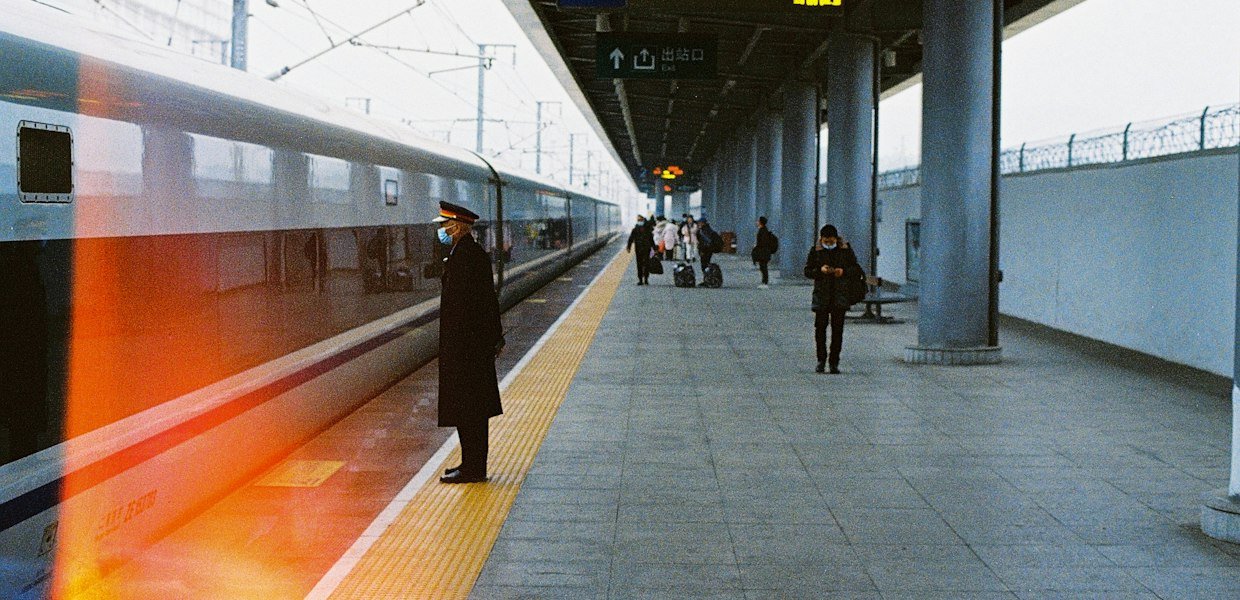 Travelers walking through an Asian train station for a guide on whether 12Go is legit