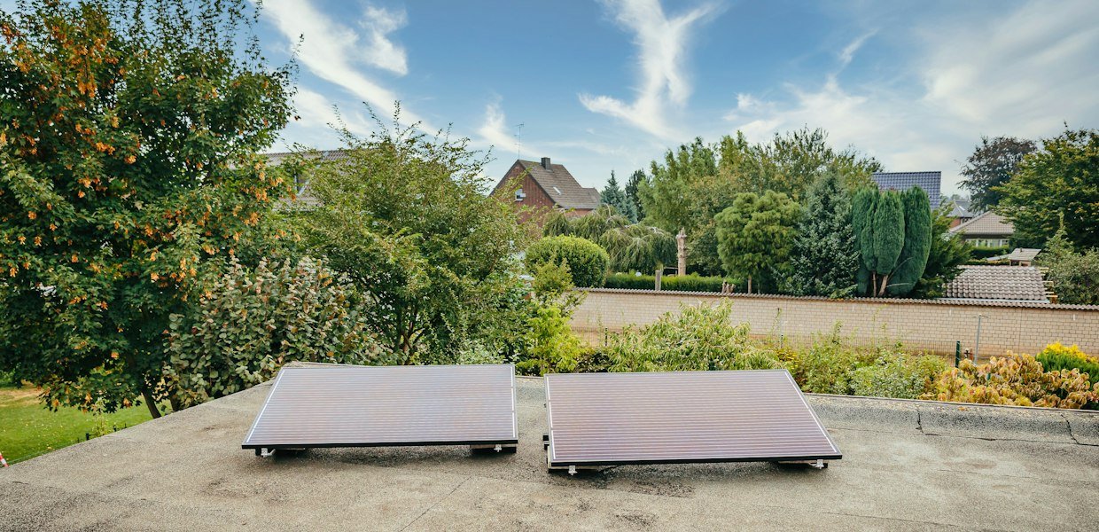 two solar panels on a rooftop with trees in the background, the kind of setup an ALLPOWERS solar generator is designed to charge from