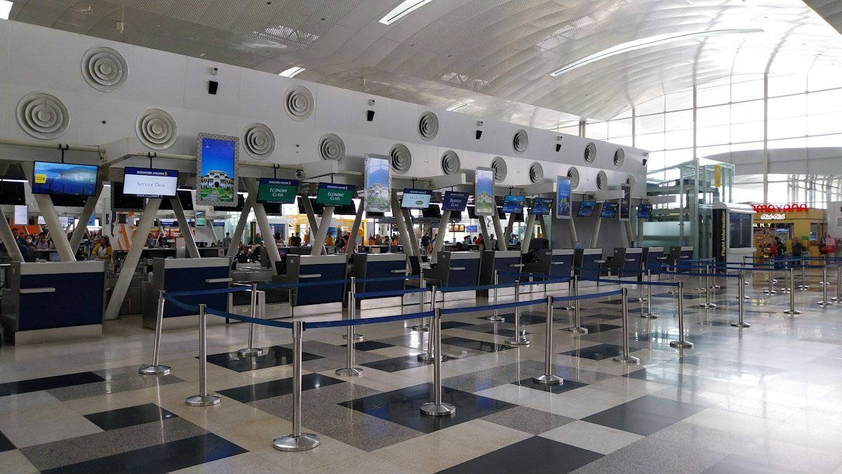 Airport check-in area where checked baggage is weighed before a Qatar Airways flight